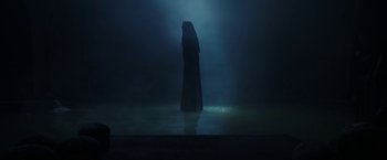 Movie still from “The Nun” (2018), directed by Corin Hardy – A person standing in the middle of a dark room; Wide shot, Low angle