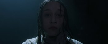 Movie still from “The Nun” (2018), directed by Corin Hardy – A young girl with wet hair in a dark room; Close Up shot, Low angle