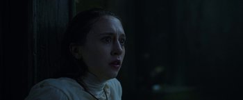 Movie still from “The Nun” (2018), directed by Corin Hardy – A young woman looking into the distance in the dark; Close Up shot, Over the shoulder angle