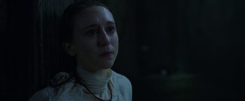 Movie still from “The Nun” (2018), directed by Corin Hardy – A woman in a white shirt is looking at the camera; Close Up shot, Over the shoulder angle