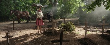 Movie still from “The Nun” (2018), directed by Corin Hardy – A woman standing in front of a grave in a cemetery; Wide shot, High angle