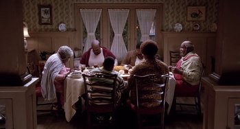 Movie still from “The Nutty Professor” (1996), directed by Tom Shadyac – A group of people sitting around a table eating food; Wide shot, High angle