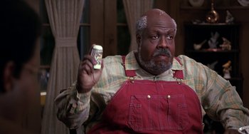 Movie still from “The Nutty Professor” (1996), directed by Tom Shadyac – A man holding a remote control in his hand; Medium shot, High angle
