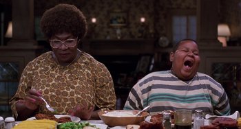 Movie still from “The Nutty Professor” (1996), directed by Tom Shadyac – Two people sitting at a table with a plate of food in front of them; Medium shot, High angle