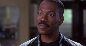 Movie still from “The Nutty Professor” (1996), directed by Tom Shadyac – A person wearing a jacket; Close Up shot, Over the shoulder angle
