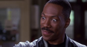 Movie still from “The Nutty Professor” (1996), directed by Tom Shadyac – A person wearing a jacket; Close Up shot, Over the shoulder angle