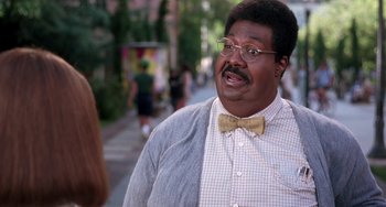 Movie still from “The Nutty Professor” (1996), directed by Tom Shadyac – A person wearing glasses and a bow tie; Medium shot, Over the shoulder angle