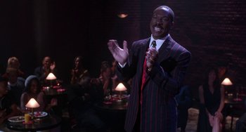 Movie still from “The Nutty Professor” (1996), directed by Tom Shadyac – A man in a striped suit clapping his hands; Medium shot, High angle