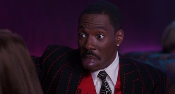 Movie still from “The Nutty Professor” (1996), directed by Tom Shadyac – A person wearing a suit and tie; Close Up shot, Low angle