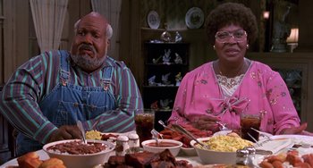 Movie still from “The Nutty Professor” (1996), directed by Tom Shadyac – A man and a woman sitting at a dinner table; Medium shot, High angle