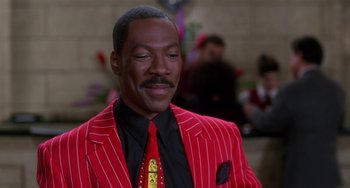 Movie still from “The Nutty Professor” (1996), directed by Tom Shadyac – A man wearing a red suit and a red tie; Close Up shot, Low angle