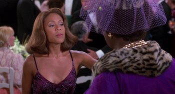 Movie still from “The Nutty Professor” (1996), directed by Tom Shadyac – A woman in a purple dress talking to another woman in a purple dress; Close Up shot, Over the shoulder angle