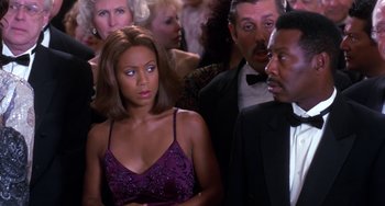 Movie still from “The Nutty Professor” (1996), directed by Tom Shadyac – A group of people standing around each other in a room; Close Up shot, Over the shoulder angle