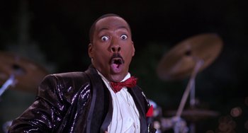 Movie still from “The Nutty Professor” (1996), directed by Tom Shadyac – A person wearing a suit and a bow tie; Close Up shot, Low angle