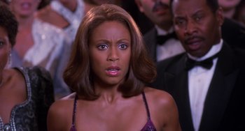 Movie still from “The Nutty Professor” (1996), directed by Tom Shadyac – A woman in a purple dress looking at the camera; Close Up shot, High angle