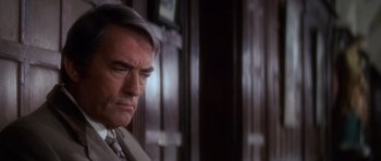 Movie still from “The Omen” (1976), directed by Richard Donner – An older man in a suit and tie looking down; Close Up shot, Over the shoulder angle
