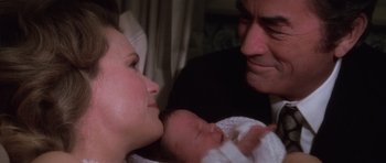 Movie still from “The Omen” (1976), directed by Richard Donner – A man and a woman holding a newborn baby; Close Up shot, High angle
