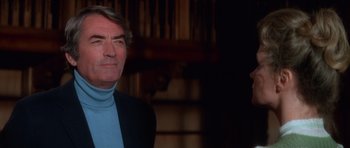 Movie still from “The Omen” (1976), directed by Richard Donner – An older man wearing a blue shirt and a black jacket; Close Up shot, Low angle