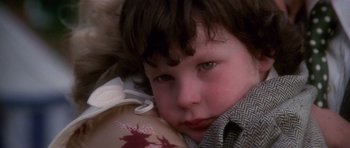 Movie still from “The Omen” (1976), directed by Richard Donner – A child with a tattoo on his shoulder; Close Up shot, High angle