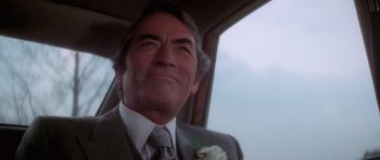 Movie still from “The Omen” (1976), directed by Richard Donner – A person wearing a suit and tie; Close Up shot, Low angle