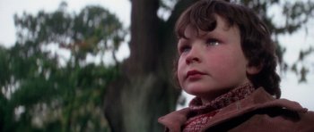 Movie still from “The Omen” (1976), directed by Richard Donner – A child wearing a scarf; Close Up shot, Low angle
