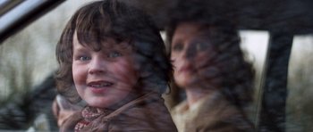 Movie still from “The Omen” (1976), directed by Richard Donner – A woman and a man looking through a window; Close Up shot, Over the shoulder angle
