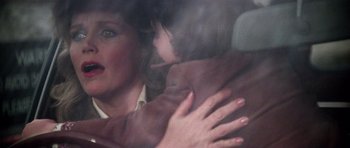 Movie still from “The Omen” (1976), directed by Richard Donner – A woman holding a child in her arms in a car; Close Up shot, Over the shoulder angle