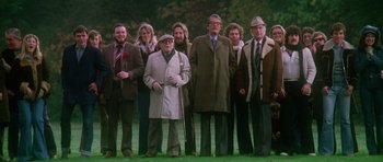 Movie still from “The Omen” (1976), directed by Richard Donner – A group of people standing in a field; Wide shot, High angle