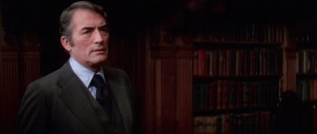 Movie still from “The Omen” (1976), directed by Richard Donner – A man in a suit and tie in a room; Close Up shot, Over the shoulder angle