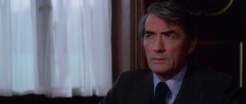 Movie still from “The Omen” (1976), directed by Richard Donner – A person wearing a suit and tie; Close Up shot, High angle