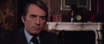 Movie still from “The Omen” (1976), directed by Richard Donner – A person wearing a suit and tie; Close Up shot, Over the shoulder angle