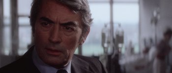 Movie still from “The Omen” (1976), directed by Richard Donner – An older man in a suit and tie looking to his left; Close Up shot, Over the shoulder angle