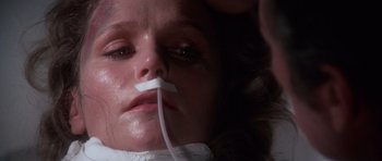 Movie still from “The Omen” (1976), directed by Richard Donner – A woman with a tube in her mouth; Close Up shot, Overhead angle