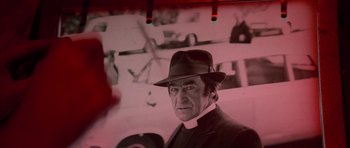 Movie still from “The Omen” (1976), directed by Richard Donner – A black and white photo of a man wearing a hat; Close Up shot, Low angle