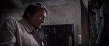 Movie still from “The Omen” (1976), directed by Richard Donner – A person wearing a shirt; Close Up shot, Over the shoulder angle