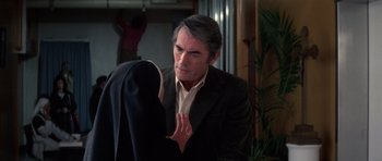 Movie still from “The Omen” (1976), directed by Richard Donner – A man in a suit and a woman in a black suit; Medium shot, Over the shoulder angle