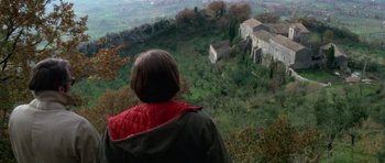 Movie still from “The Omen” (1976), directed by Richard Donner – A woman looking out over a lush green hillside; Extreme Wide shot, Over the shoulder angle