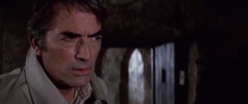 Movie still from “The Omen” (1976), directed by Richard Donner – A person wearing a suit and tie; Close Up shot, Over the shoulder angle