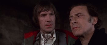 Movie still from “The Omen” (1976), directed by Richard Donner – A man and a woman looking at the camera; Close Up shot, Over the shoulder angle