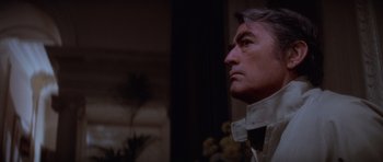 Movie still from “The Omen” (1976), directed by Richard Donner – A person wearing a white shirt; Close Up shot, Low angle