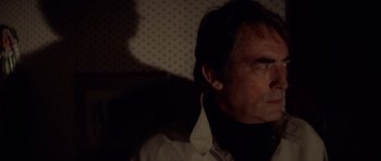 Movie still from “The Omen” (1976), directed by Richard Donner – A person wearing a white shirt; Close Up shot, Low angle