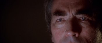 Movie still from “The Omen” (1976), directed by Richard Donner – A man's eyes with a dark background; Extreme Close Up shot, Overhead angle