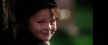 Movie still from “The Omen” (1976), directed by Richard Donner – A young child's face with lights in the background; Close Up shot, Low angle