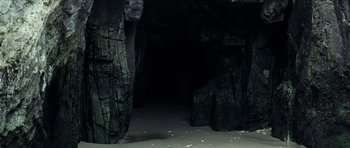 Movie still from “The Orphanage” (2007), directed by J.A. Bayona – A dark cave with a lot of rocks in it; Extreme Wide shot, High angle