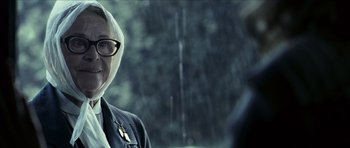 Movie still from “The Orphanage” (2007), directed by J.A. Bayona – An older woman wearing glasses and a white head scarf; Close Up shot, Over the shoulder angle