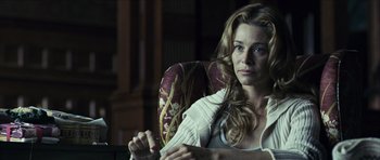 Movie still from “The Orphanage” (2007), directed by J.A. Bayona – A woman sitting in a chair looking at the camera; Close Up shot, Over the shoulder angle