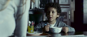 Movie still from “The Orphanage” (2007), directed by J.A. Bayona – A young boy sitting at a table with a bowl of food; Close Up shot, Over the shoulder angle