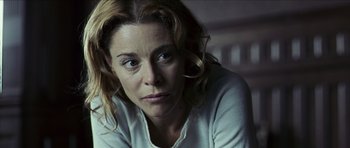 Movie still from “The Orphanage” (2007), directed by J.A. Bayona – A person sitting in a room; Close Up shot, Over the shoulder angle