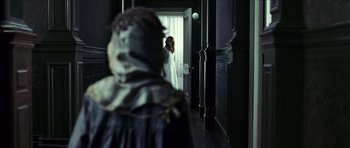 Movie still from “The Orphanage” (2007), directed by J.A. Bayona – A woman standing in front of an open door; Medium shot, Over the shoulder angle