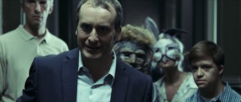 Movie still from “The Orphanage” (2007), directed by J.A. Bayona – A man in a suit standing in front of two other people; Close Up shot, Over the shoulder angle